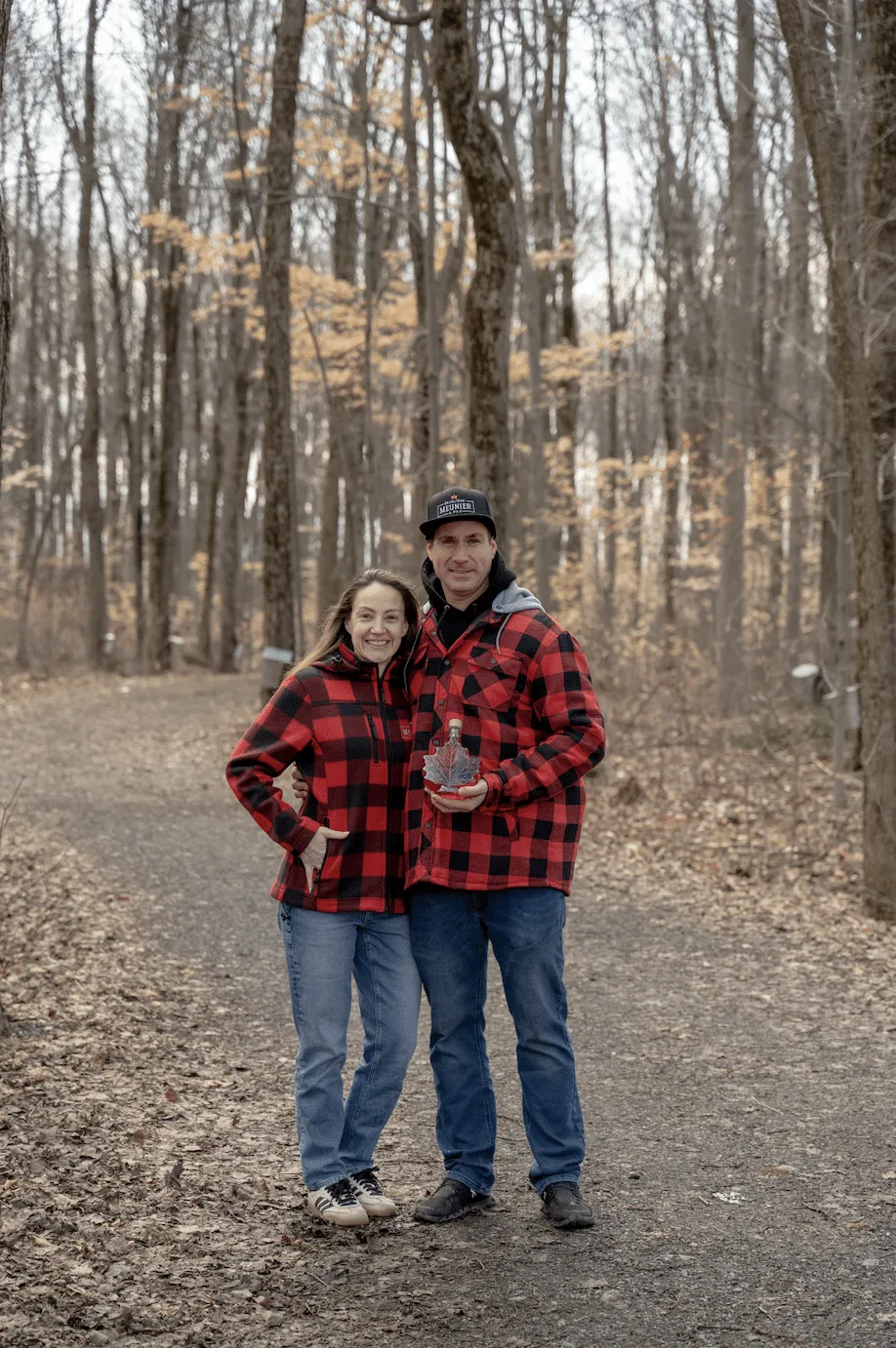 Couple de producteurs de l'Érablière Meunier en chemises à carreaux dans leur érablière